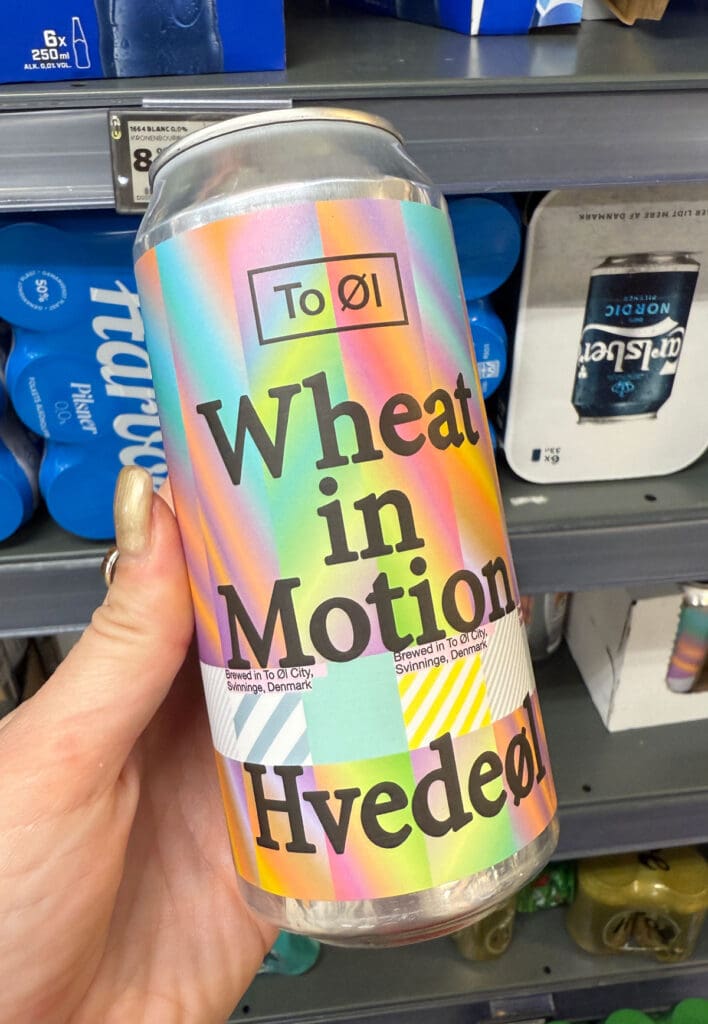 Colourful Wheat in Motion drinks packaging being examined in front of competing products on a retail shelf.