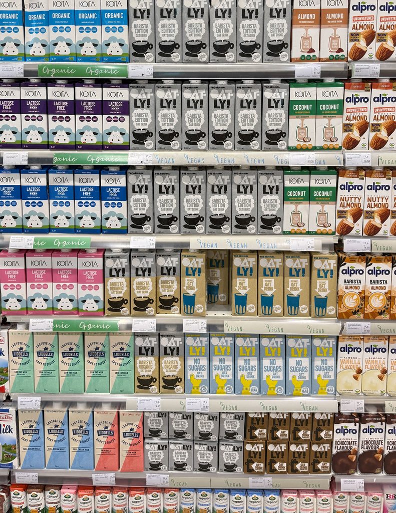 Plant-based milk packaging displayed across a crowded retail shelf, demonstrating shelf appeal, category codes and brand differentiation.
