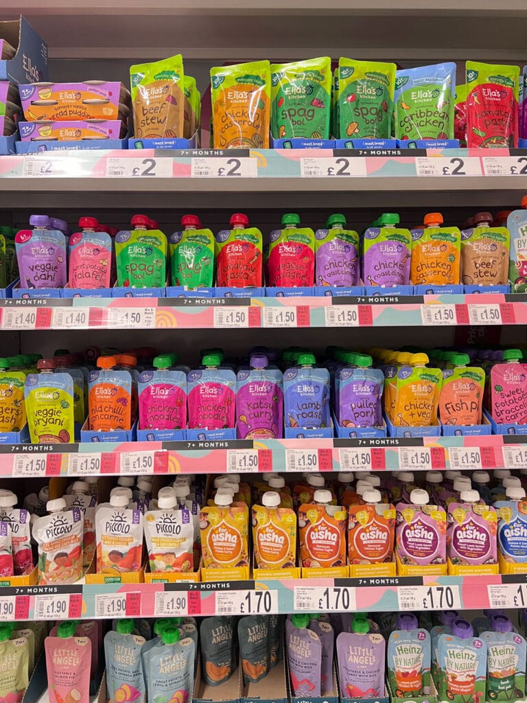 Baby food packaging displayed across a supermarket shelf, showing competing approaches to colour, hierarchy and product navigation.